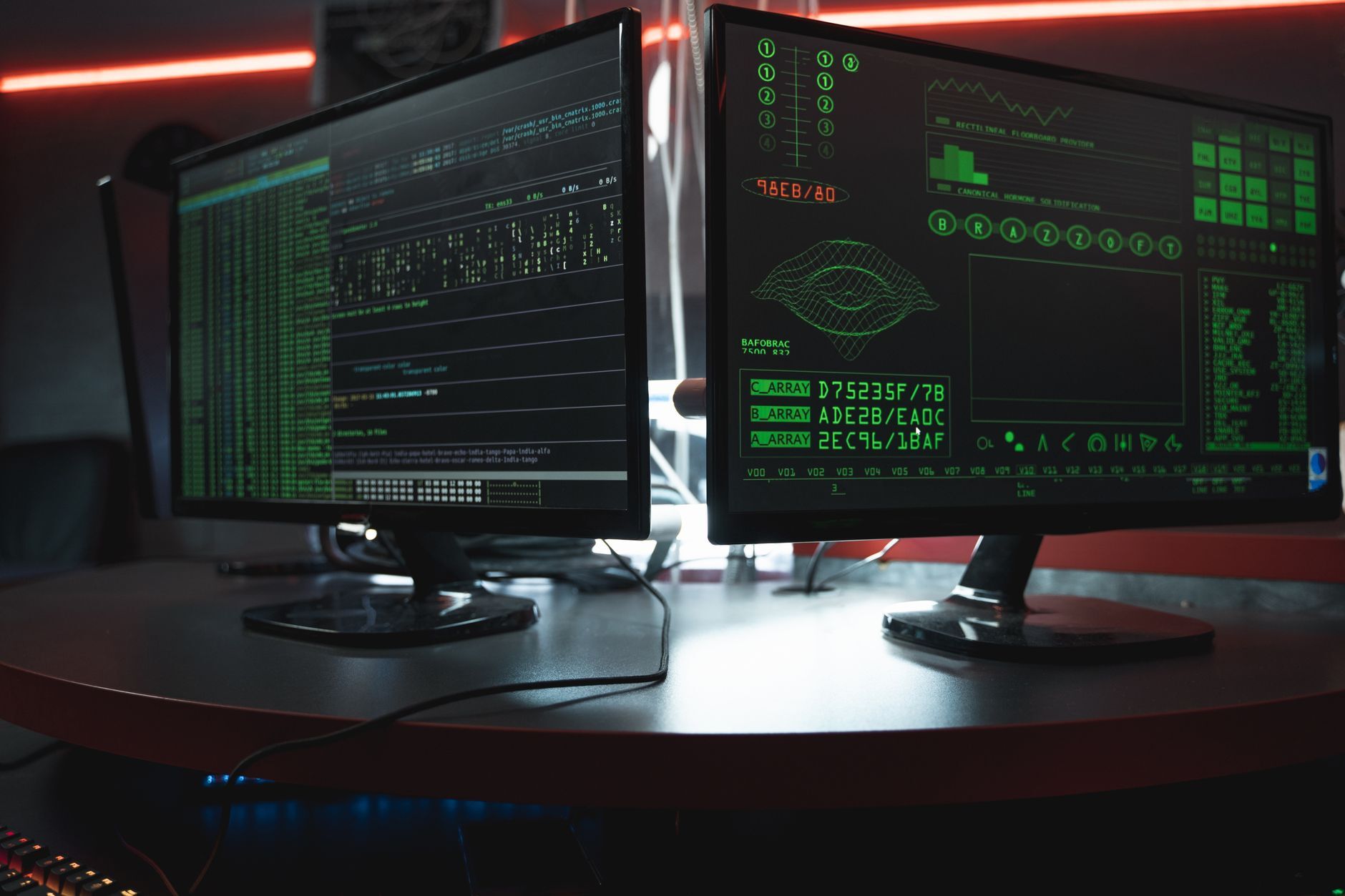Close-up of dual computer monitors with green coding interfaces in a dark room, highlighting cyber security themes, illustrating Datadog Cloud Security Management: Vulnerability and Misconfiguration Scanning for SOC 2 and ISO 27001
