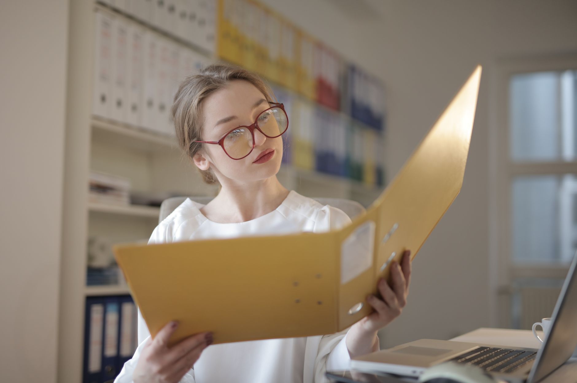 Caucasian woman intensely reading documents in an office setting, illustrating SOC 2 Audit Firms in Canada (2026): How to Choose a SOC 2 Auditor