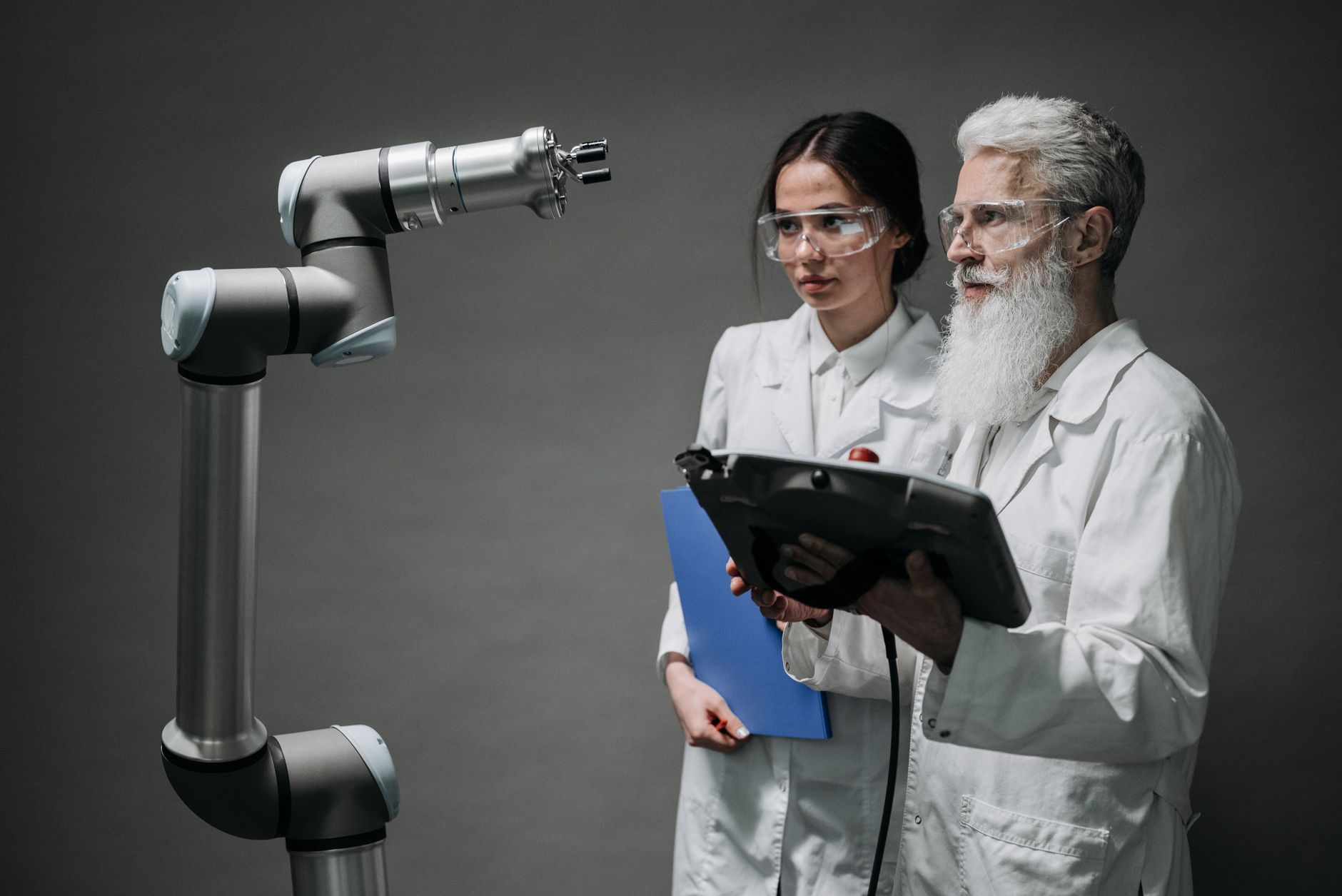 Researchers examining a robotic arm, showcasing technology and innovation, illustrating Top ISO 42001 Consultants in Canada (2026): A Buyer's Guide