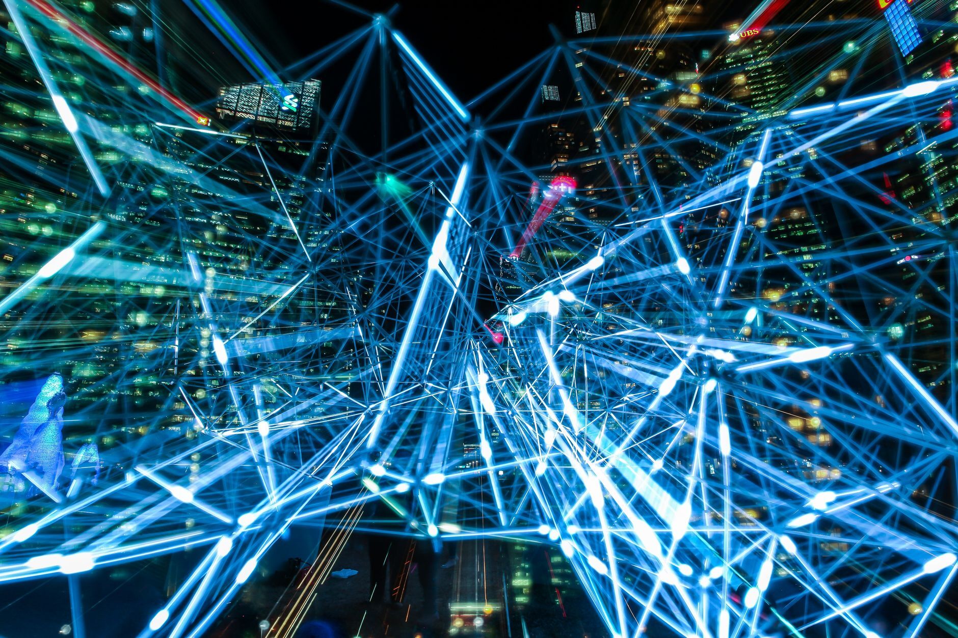 Dynamic urban scene showcasing interconnected light trails representing digital communication networks, illustrating What Is a Neocloud? Definition, Examples, and What It Means for Compliance
